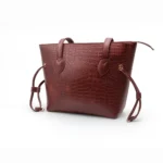 Burgundy Croc Textured Tote Bag at Nouvaid Center. Luxurious burgundy faux leather with embossed crocodile texture, spacious, and perfect for everyday use