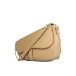 Nude beige crescent-shaped saddle bag with gold chain strap and smooth vegan leather finish.