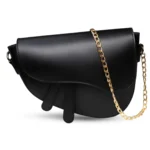 Mini black crescent-shaped saddle bag featuring a gold chain strap and smooth matte vegan leather.