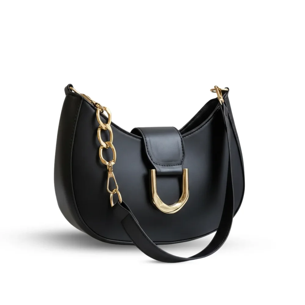 Black half-moon hobo bag with a large gold U-shaped buckle and a chunky gold link chain strap.