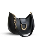 Black half-moon hobo bag with a large gold U-shaped buckle and a chunky gold link chain strap.