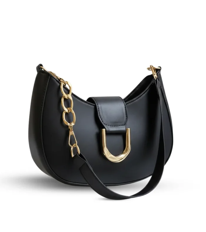 Black half-moon hobo bag with a large gold U-shaped buckle and a chunky gold link chain strap.