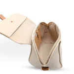 Beige pebbled vegan leather crossbody bag with a caramel brown magnetic flap detail and adjustable shoulder strap.