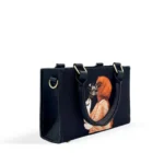 Black canvas tote bag featuring minimalist hijab girl illustration with floral accents and black leather handles
