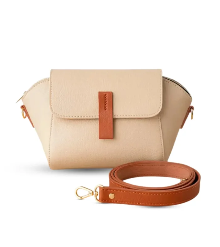 Beige pebbled vegan leather crossbody bag with a caramel brown magnetic flap detail and adjustable shoulder strap.