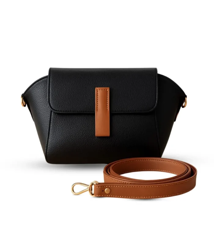 Black pebbled vegan leather crossbody bag with a caramel brown magnetic flap detail and adjustable shoulder strap.