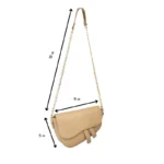Nude beige crescent-shaped saddle bag with gold chain strap and smooth vegan leather finish.