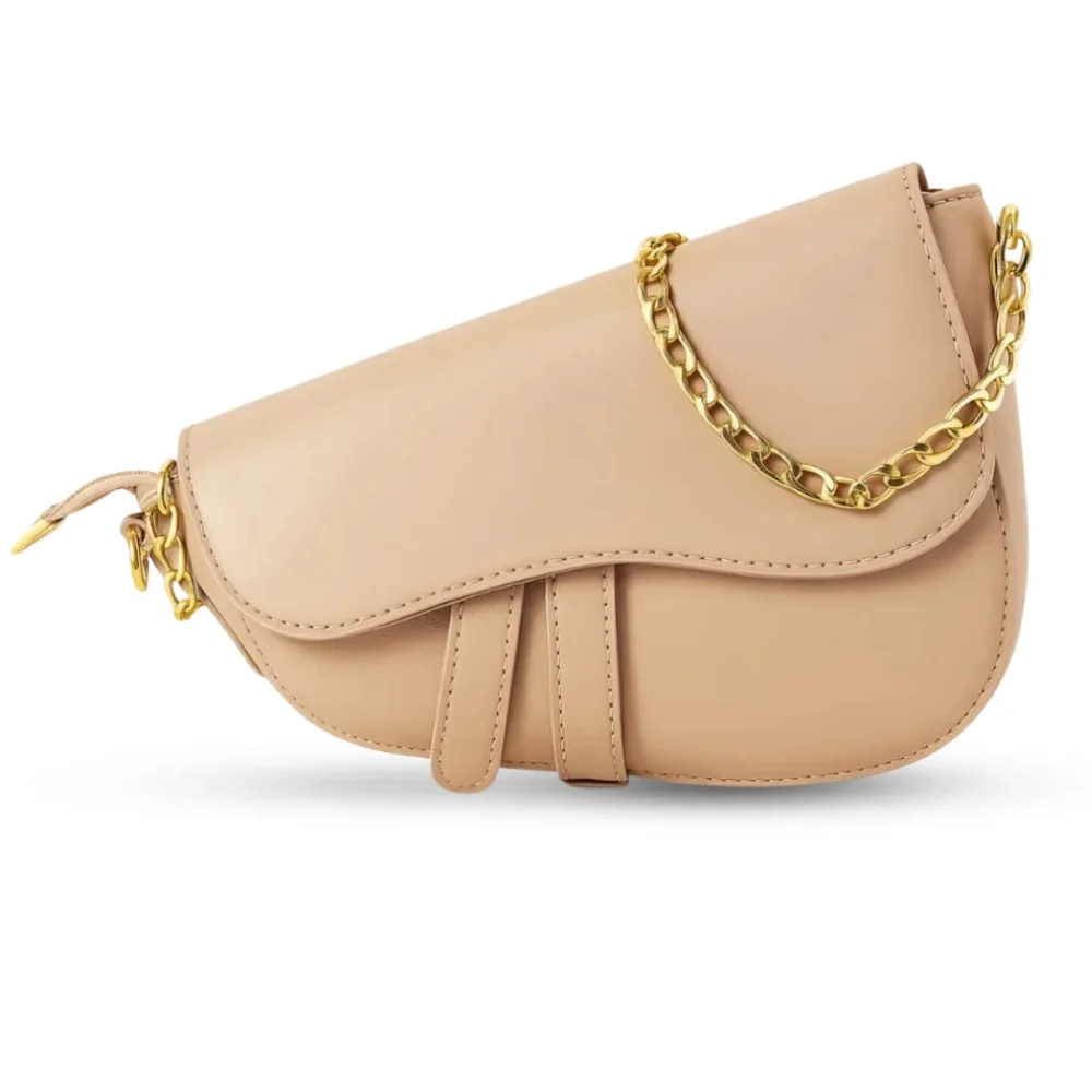 Nude beige crescent-shaped saddle bag with gold chain strap and smooth vegan leather finish.
