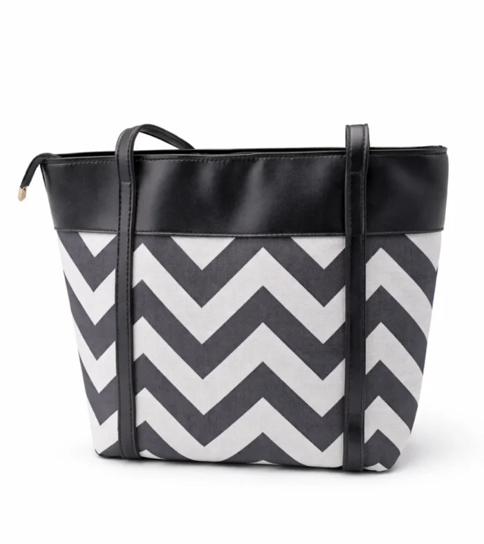 Large tote bag with a black and grey chevron pattern, black leather handles, and a secure top zipper.