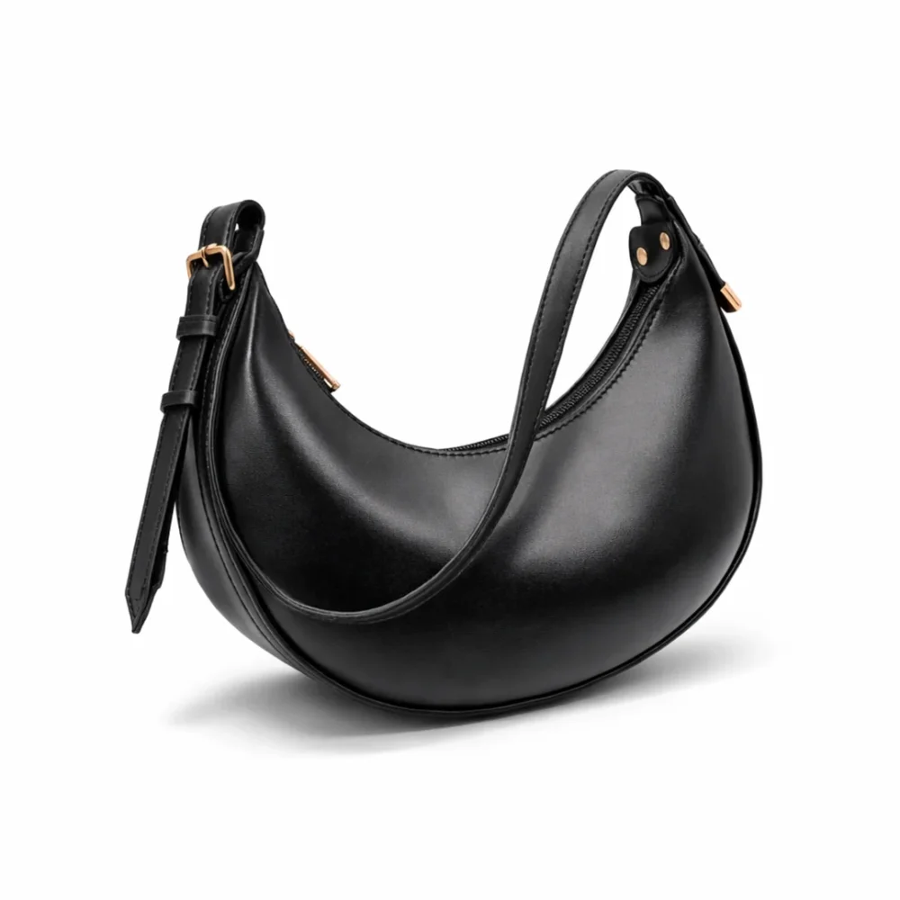 Side view of a smooth black crescent hobo bag with gold zippers and an integrated shoulder strap.